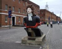 Figurehead of HMS Benbow, with some of the fine Georgian naval buildings beyond