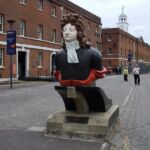 Figurehead of HMS Benbow, with some of the fine Georgian naval buildings beyond